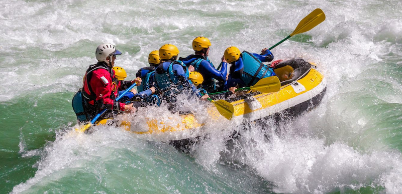 Adventure seekers white-water rafting on Seti River near Pokhara surrounded by lush hills