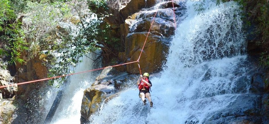 Adventurer rappelling down a waterfall during canyoning tour in Lwang Ghalel near Pokhara