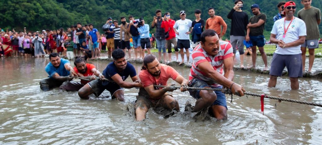 Foreign and local participants enjoy mud games and rice planting at the National Rice Plantation Festival. Game dori tanne.