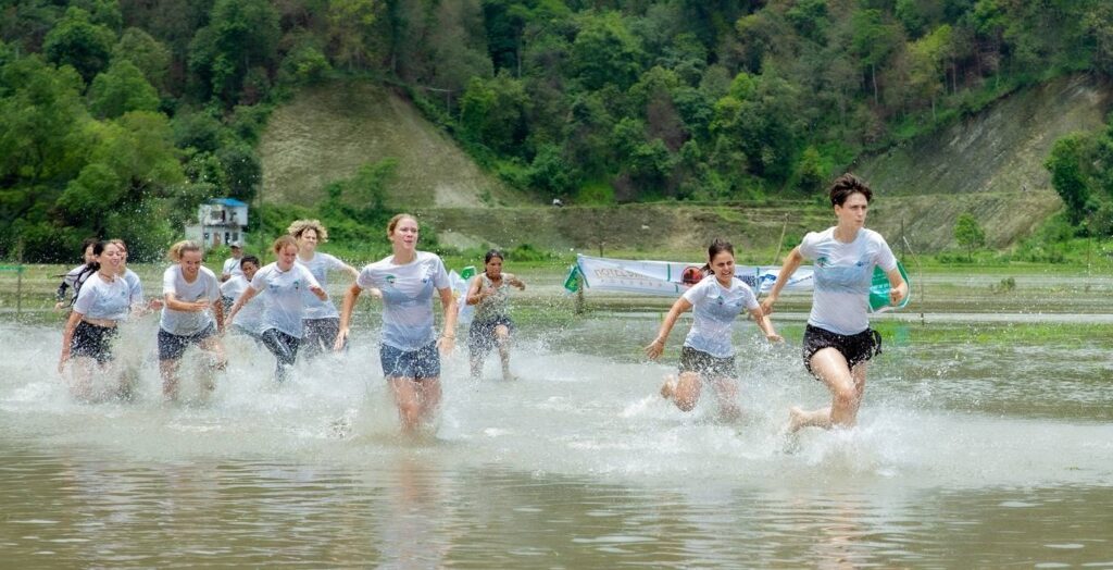 Foreign and local participants enjoy mud games and rice planting at the National Rice Plantation Festival. Running Game.